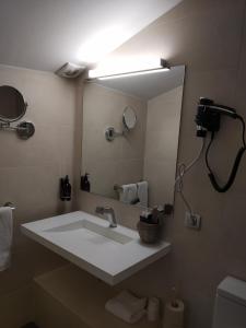 baño con lavabo y espejo grande en Hotel Olot Centre en Olot