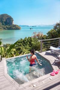 Eine Frau steht in einer Whirlpool-Badewanne mit dem Meer in der Unterkunft Paradise KohYao in Ko Yao Noi