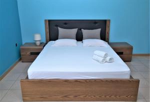 a bedroom with a large bed with two towels on it at Marianna Appartaments in Plataria