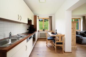 cocina con fregadero y mesa en Ferienappartements Schrattengut, en Abtenau
