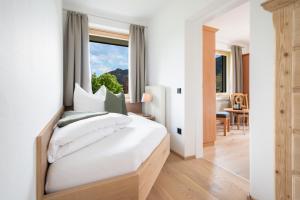 a bedroom with a large white bed with a window at Ferienappartements Schrattengut in Abtenau