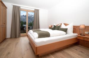 a bedroom with a bed with white sheets and a window at Ferienappartements Schrattengut in Abtenau