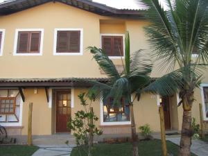 a house with two palm trees in front of it at Casa Condominio Barra de Juquehy in Juquei