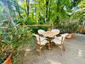- une table et des chaises en bois dans le jardin dans l'établissement Ferienwohnungen an der Salvatorkirche - zentrales Apartmenthaus mit Terrasse, à Cobourg