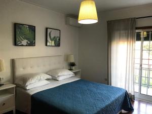 1 dormitorio con 1 cama con manta azul y ventana en Casa do Olival, en Peso da Régua