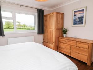 a bedroom with a bed and a dresser and a window at Ashlea in Launceston