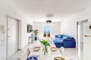 a living room with a blue couch and a table at Villa Rusinella Minimalist Retreat with Sea Views by Feeling Italy in Massa Lubrense