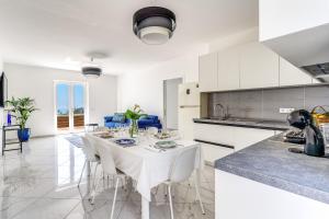 a kitchen and dining room with a table and chairs at Villa Rusinella Minimalist Retreat with Sea Views by Feeling Italy in Massa Lubrense