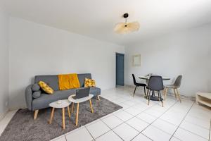 a living room with a couch and a table at Le beau T3 de St Jory climatisation in Saint-Jory