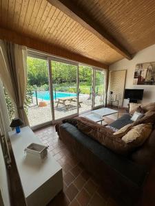 a living room with a couch and a view of a pool at Maison indépendante avec piscine in Jaujac