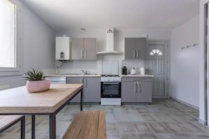 a kitchen with white appliances and a wooden table at Le beau T3 de St Jory climatisation in Saint-Jory