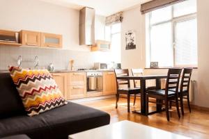 un salon avec un canapé et une table dans une cuisine dans l'établissement City Center 2BDR apartment near Rustaveli Av., à Tbilissi