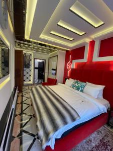 a bedroom with a large bed with a red headboard at Le palace suite by pestana hôtel in Casablanca