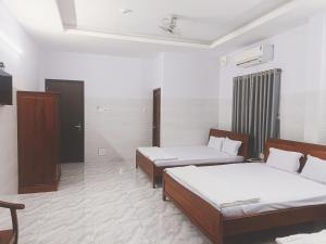 Cette chambre comprend 2 lits et une télévision. dans l'établissement KHÁCH SẠN VĂN KHANG, à Bạc Liêu