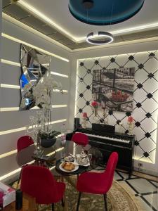 a dining room with red chairs and a table and a piano at Le palace suite by pestana hôtel in Casablanca