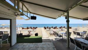 una terraza con mesas y sillas en la playa en VaspyFlogitaRooms, en Flogita