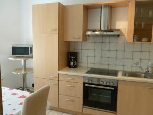 a small kitchen with a stove and a sink at Ostsee Ferienwohnung in Schönberg inkl. 2 Leihfahrräder in Schönberg in Holstein