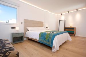 a white bedroom with a bed and a window at Malagueta Luz by Renthas in Málaga