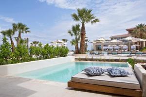 a pool at a resort with two pillows on a bed at Cora Hotel & Spa in Afitos