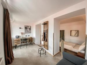 a living room with a bed and a desk at Sporthotel Igls in Innsbruck