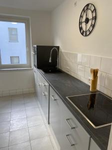 uma cozinha com um balcão com um relógio na parede em 3 Zimmer City Apartment, TV, Netflix, WLAN, Free Parking em Bielefeld