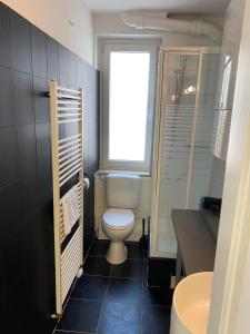 uma casa de banho com um WC e uma janela em 3 Zimmer City Apartment, TV, Netflix, WLAN, Free Parking em Bielefeld