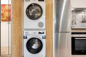 two washing machines and a refrigerator in a kitchen at II-I Hub Luxury New Apartments in Barcelona