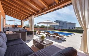 a living room with a couch and an umbrella and a pool at Cozy Home In Skatari With Outdoor Swimming Pool in Šikići