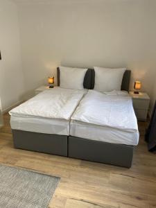 a bed in a bedroom with two lamps on two tables at 3 Zimmer City Apartment, TV, Netflix, WLAN, Free Parking in Bielefeld