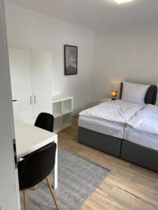 een slaapkamer met een bed, een tafel en een bureau bij 3 Zimmer City Apartment, TV, Netflix, WLAN, Free Parking in Bielefeld