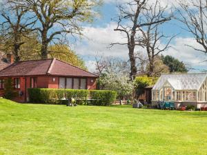 a house in a yard with a green lawn at Swallowtail Lodge in Brundall