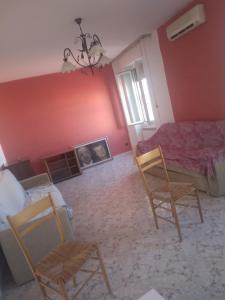 sala de estar con 2 sillas y sofá en Casa Costantino, en Campanedda