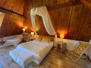 a bedroom with a bed and a chair in a room at Maison d’hôtes les Méans in Méolans