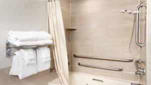 a bathroom with a shower and a bath tub with towels at Holiday Inn & Suites Ocean City, an IHG Hotel in Ocean City