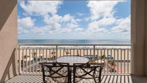 uma varanda com uma mesa e vista para a praia em Holiday Inn & Suites Ocean City, an IHG Hotel em Ocean City