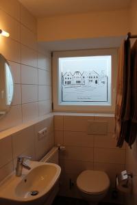 baño con lavabo y aseo y ventana en Gasthof Klosterkeller en Kronach