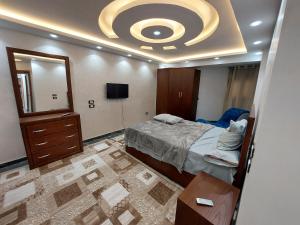 - une chambre avec un lit, un miroir et une télévision dans l'établissement جامعة الدول العربية ميدان سفنكس, au Caire