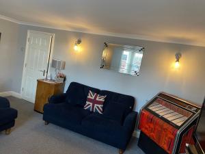 a living room with a blue couch and a mirror at Imperial House Holiday Let in Herne Bay