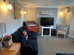 a living room with a couch and a flat screen tv at Imperial House Holiday Let in Herne Bay