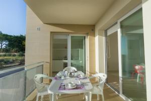 einen weißen Tisch und Stühle auf dem Balkon in der Unterkunft Appartamenti Sud Est in Marina di Ragusa