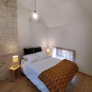 1 dormitorio con 1 cama blanca grande con lámpara en Manoir de L'Echauguette, en Laignes