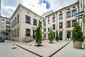 un grupo de edificios con árboles en un patio en Vistula Loft Blue Apartment, en Varsovia