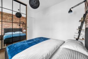 1 dormitorio con cama y pared de ladrillo en Vistula Loft Blue Apartment, en Varsovia