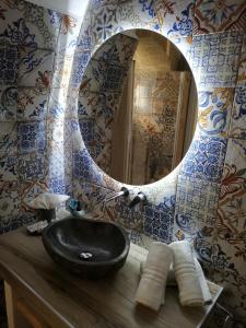 La salle de bains est pourvue d'un lavabo noir et d'un miroir. dans l'établissement SaLò Apartments, à Manfredonia