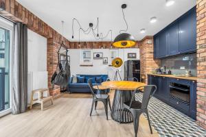 cocina y sala de estar con mesa y sillas en Vistula Loft Blue Apartment, en Varsovia