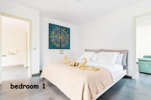 una camera da letto con un letto con due peluche sopra di Villa Collection Madroñal - Heated Pool BBQ XBox ad Adeje