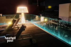 a pool at night with chairs and a lamp at Villa Collection Madroñal - Heated Pool BBQ XBox in Adeje