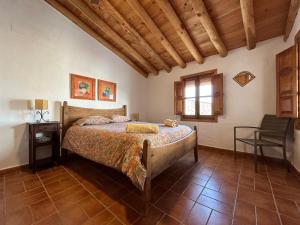 Un dormitorio con una cama y una silla dentro. en Campanario 3, en Alájar