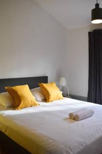 uma cama com almofadas amarelas e duas toalhas em Private 4P top floor - hostel apartment em Amsterdã