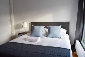 un letto con cuscini blu e bianchi in una stanza di Private 4P top floor - hostel apartment ad Amsterdam